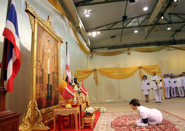  	Thủ tướng Thái Lan Yingluck Shinawatra cúi rạp người trước bức ảnh chân dung nhà vua Bhumibol Adulyadej tại trụ sở đảng Pue Thái ở Bangkok.