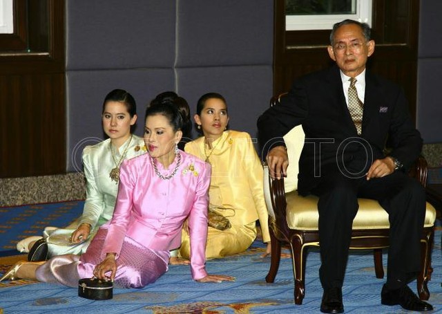  	Nhà vua Thái Lan Bhomibol Adulyadej ngồi trên ghế chờ đón khách trong một sự kiện năm 2006. Trong khi đó, công chúa Ubol Ratana và hai tiểu công chúa, con gái bà Ubol Ratana ngồi dưới sàn, thể hiện sự tôn kính với ngài.