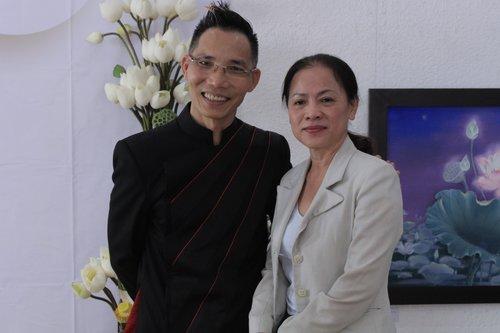 Họa sĩ Trần Huy Khuê (trái) cùng khán giả trong buổi triển lãm.