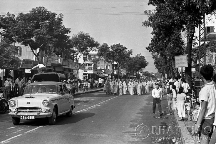 03. Sau khi xong khóa lễ, chư tăng ni xuống đường trực chỉ đi về phía ngã tư Phan Đình Phùng và Lê Văn Duyệt. Chiếc xe Austin của cư sĩ Trần Quang Thuận chở HT. Thích Quảng Đức (ngồi sau) và thầy Thích Trí Minh (ngồi trước) [● theo lời thuật của HT. Thích Đức Nhơn