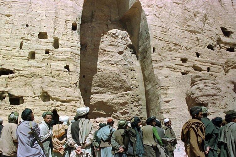 Các tay súng Taliban đứng dưới phần còn lại của một trong hai bức tượng Phật bị phá hủy hồi tháng 3/2001. Lãnh đạo nhóm khi đó, Mullah Mohammed Omar chính là người trực tiếp ra lệnh phá hủy 2 bức tượng. Ảnh: AP.