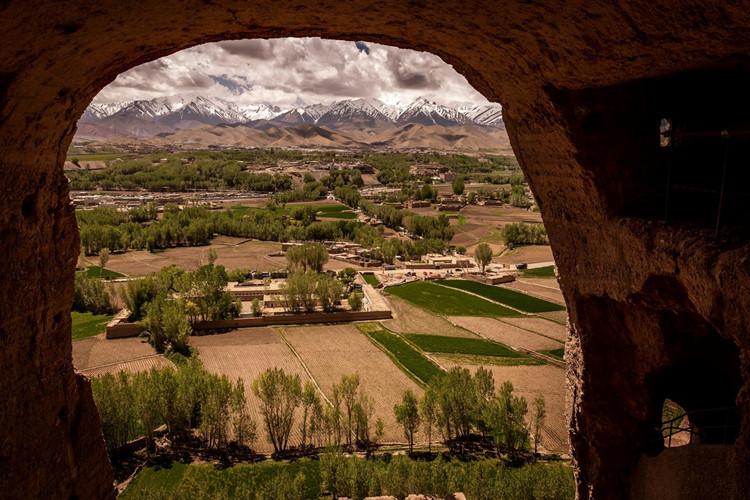Khung cảnh của thung lũng Bamiyan, với những dãy núi phủ tuyết trắng ở phía xa và những cánh đồng màu xanh, khi nhìn ra từ vị trí đặt bức tượng trước đây. Ảnh: New York Times.